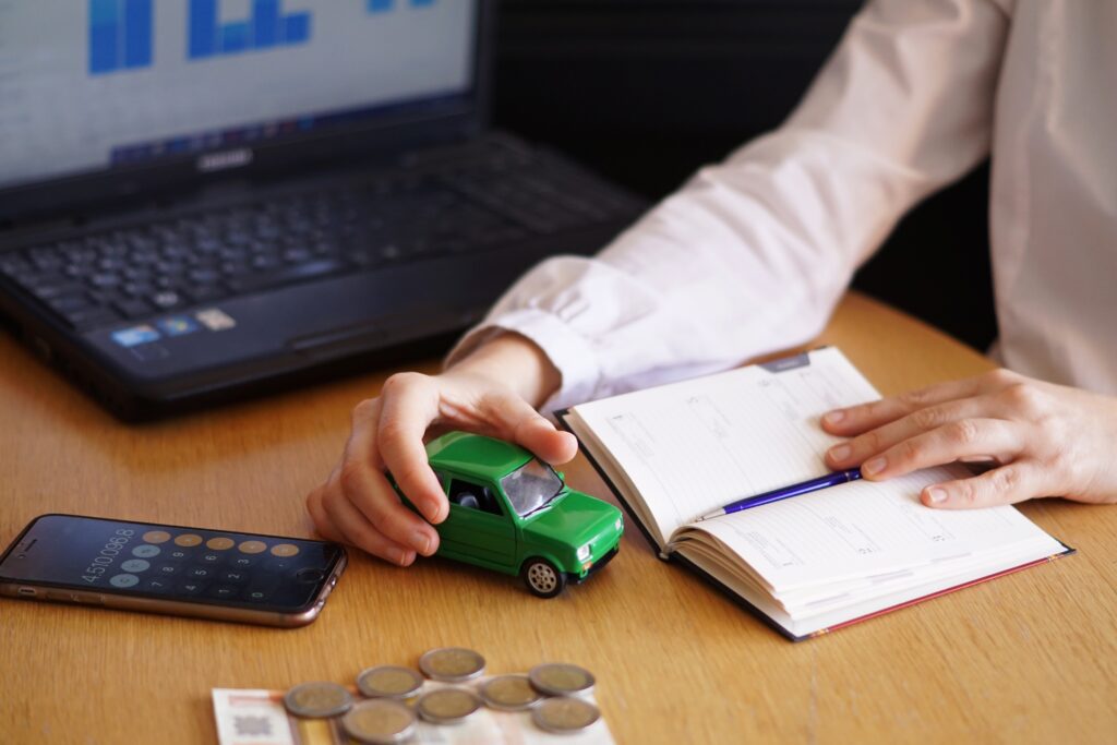Fleet financing options illustrated by a business owner planning vehicle purchases, reviewing budgets and loan calculations while evaluating costs for expanding or upgrading a trucking fleet.