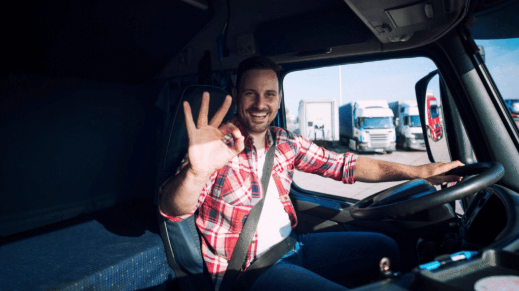 Truck driver in cab after professional driver training, showing confidence and readiness.