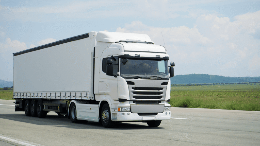 Invest in new trucks to improve reliability and efficiency, shown by a modern white semi-truck operating on an open highway with improved fuel performance and lower maintenance costs.