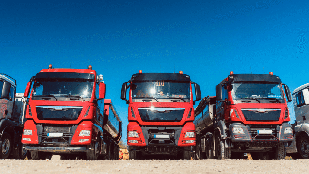 Trucking business structure image showing multiple commercial trucks lined up in a fleet yard, representing the foundation and growth of a structured trucking company.